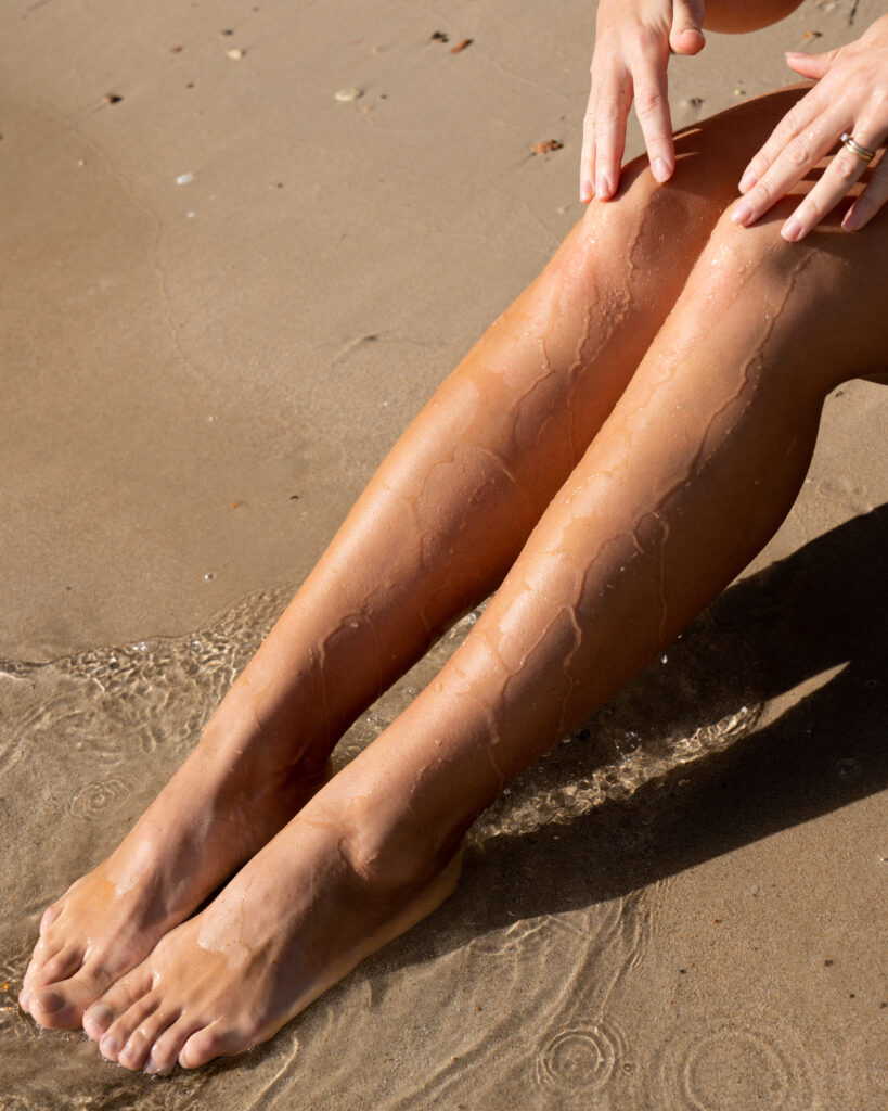 Fuße im Wasser am Strand